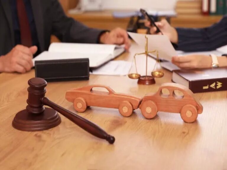 Wooden toy cars and gavel on a table with legal documents, representing a California lemon law case.