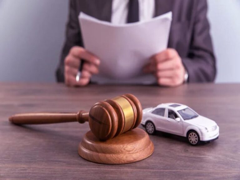 Gavel, toy car, and lawyer reviewing documents; Ohio Lemon Law.